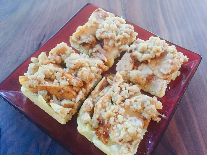 Apple Pie Bars ct and served on a red plate.