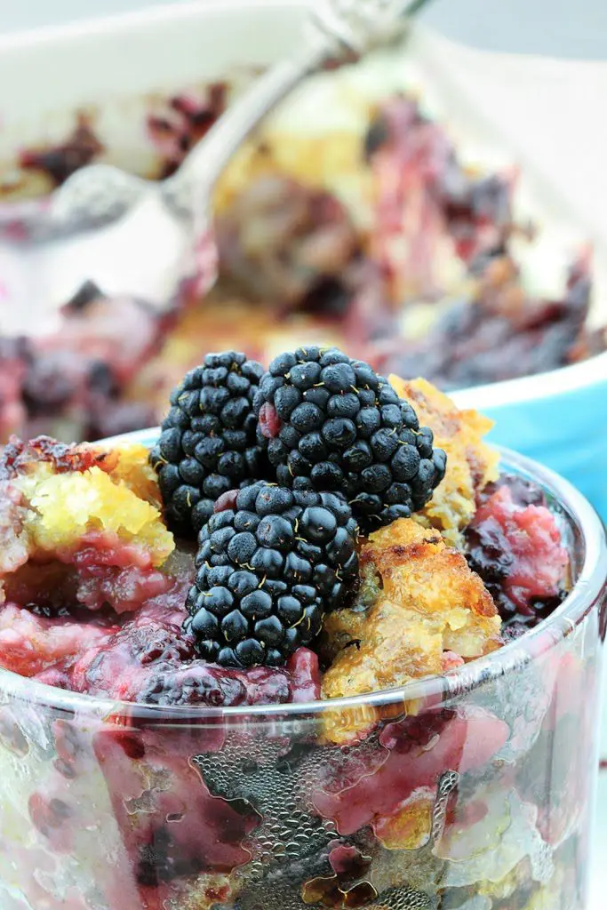 A picture of blackberry cobbler served in glass bowl.
