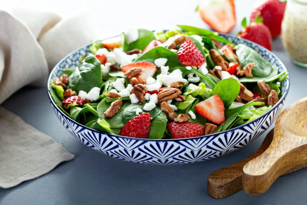 Yummy Strawberry Salad in a decorative bowl on table with napkin.