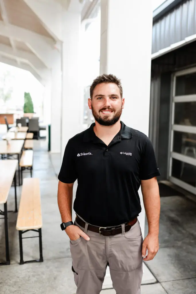 Farm Operations Manager, Jack Lanxon, standing outside of a building and smiling