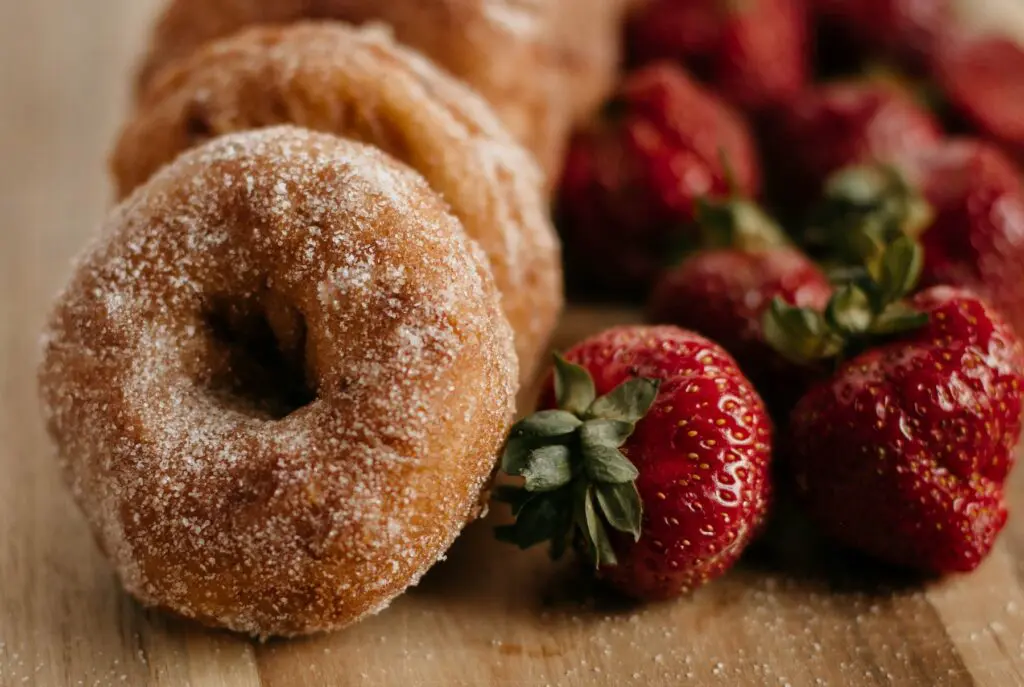 Cider Donuts & Strawberries close up on wood table.