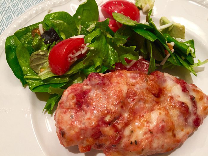 A picture of smothered italian chicken with a salad